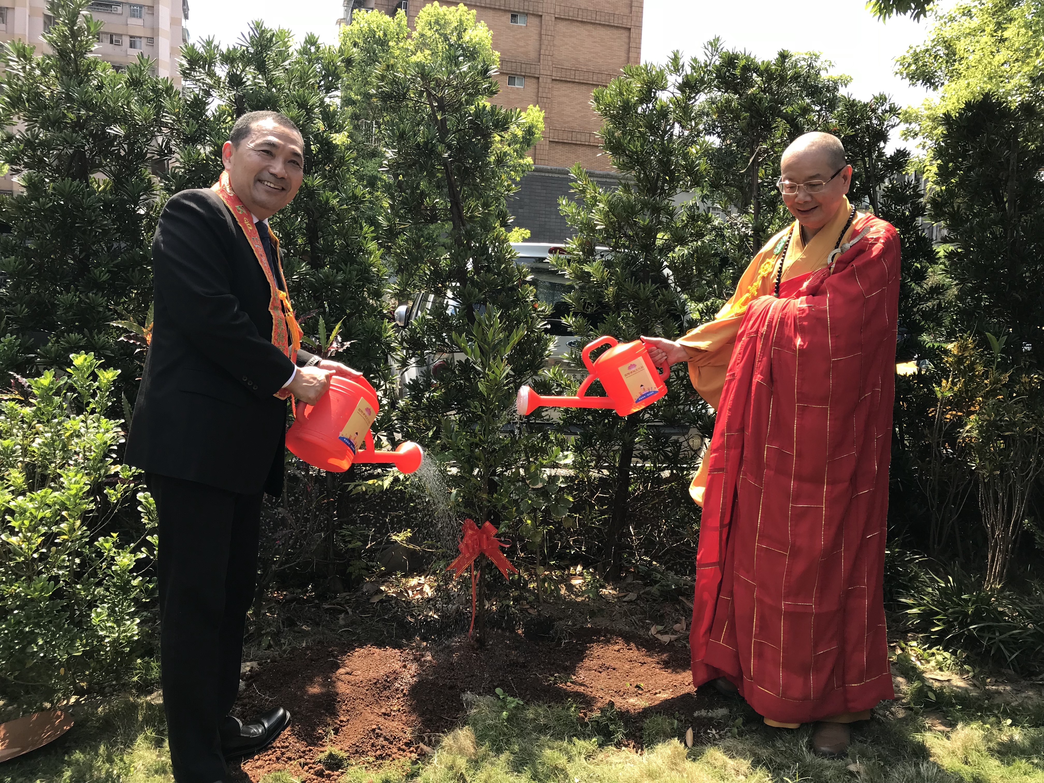 市長侯友宜（左穿西裝者）與新北市佛教會理事長也是慈法禪寺住持的淨耀法師（右），一起植樹慶祝佛誕節。
